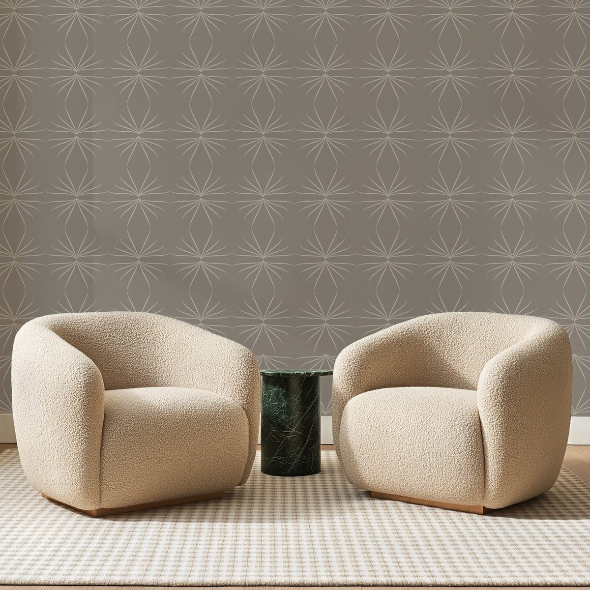 Papier peint panoramique Étoiles au Trait Taupe, posé sur toute la paroi d'un salon, derrière deux fauteuils en bouclette crème et un guéridon en marbre vert
