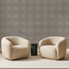 Papier peint panoramique Étoiles au Trait Taupe, posé sur toute la paroi d'un salon, derrière deux fauteuils en bouclette crème et un guéridon en marbre vert