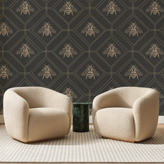 Papier peint panoramique Abeilles sur Hexagones Bruns, posé sur toute la paroi d'un salon, derrière deux fauteuils en bouclette crème et un guéridon en marbre vert