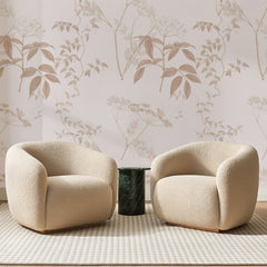 Papier peint panoramique Ombelles Sauvages Rose Poudré, posé sur toute la paroi d'un salon, derrière deux fauteuils en bouclette crème et un guéridon en marbre vert.