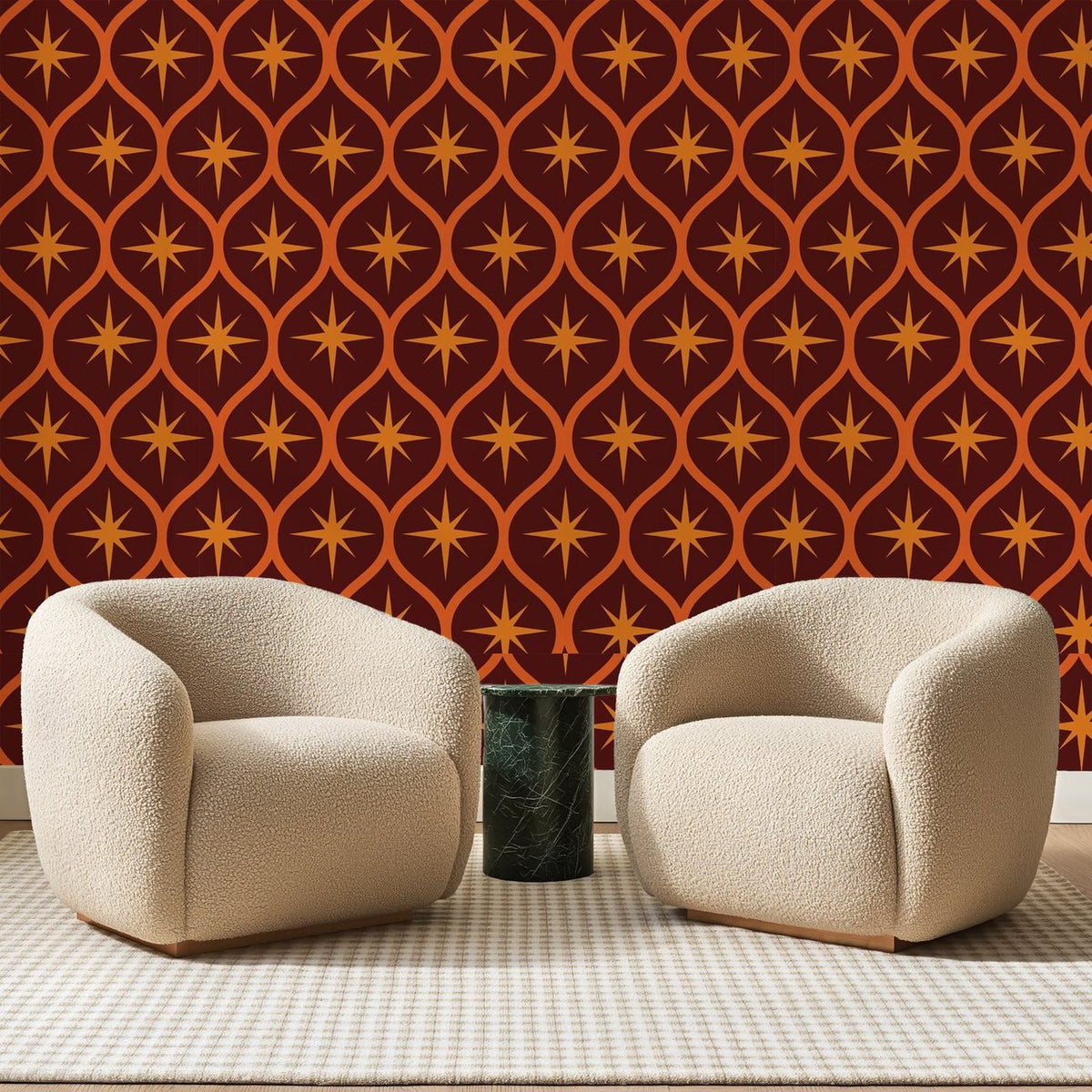 Papier peint panoramique Étoiles Orangées sur Acajou, posé sur toute la paroi d'un salon, derrière deux fauteuils en bouclette crème et un guéridon en marbre vert