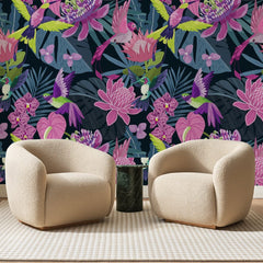 Papier peint panoramique Protéas Fuchsia sur Fond Nuit, posé sur toute la paroi d'un salon, derrière deux fauteuils en bouclette crème et un guéridon en marbre vert