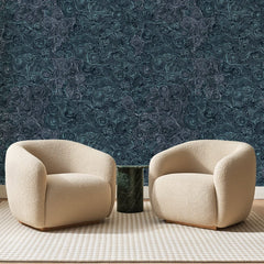 Papier peint panoramique Tourbillons Bleu Canard, posé sur toute la paroi d'un salon, derrière deux fauteuils en bouclette crème et un guéridon en marbre vert