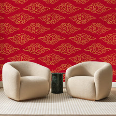 Papier peint panoramique Nuages Dorés sur Rouge Vif, posé sur toute la paroi d'un salon, derrière deux fauteuils en bouclette crème et un guéridon en marbre vert