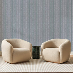 Papier peint panoramique Rayures Ikat Gris Bleuté, posé sur toute la paroi d'un salon, derrière deux fauteuils en bouclette crème et un guéridon en marbre vert