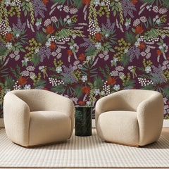 Papier peint panoramique Sous-Bois Fleuri sur Prune, posé sur toute la paroi d'un salon, derrière deux fauteuils en bouclette crème et un guéridon en marbre vert