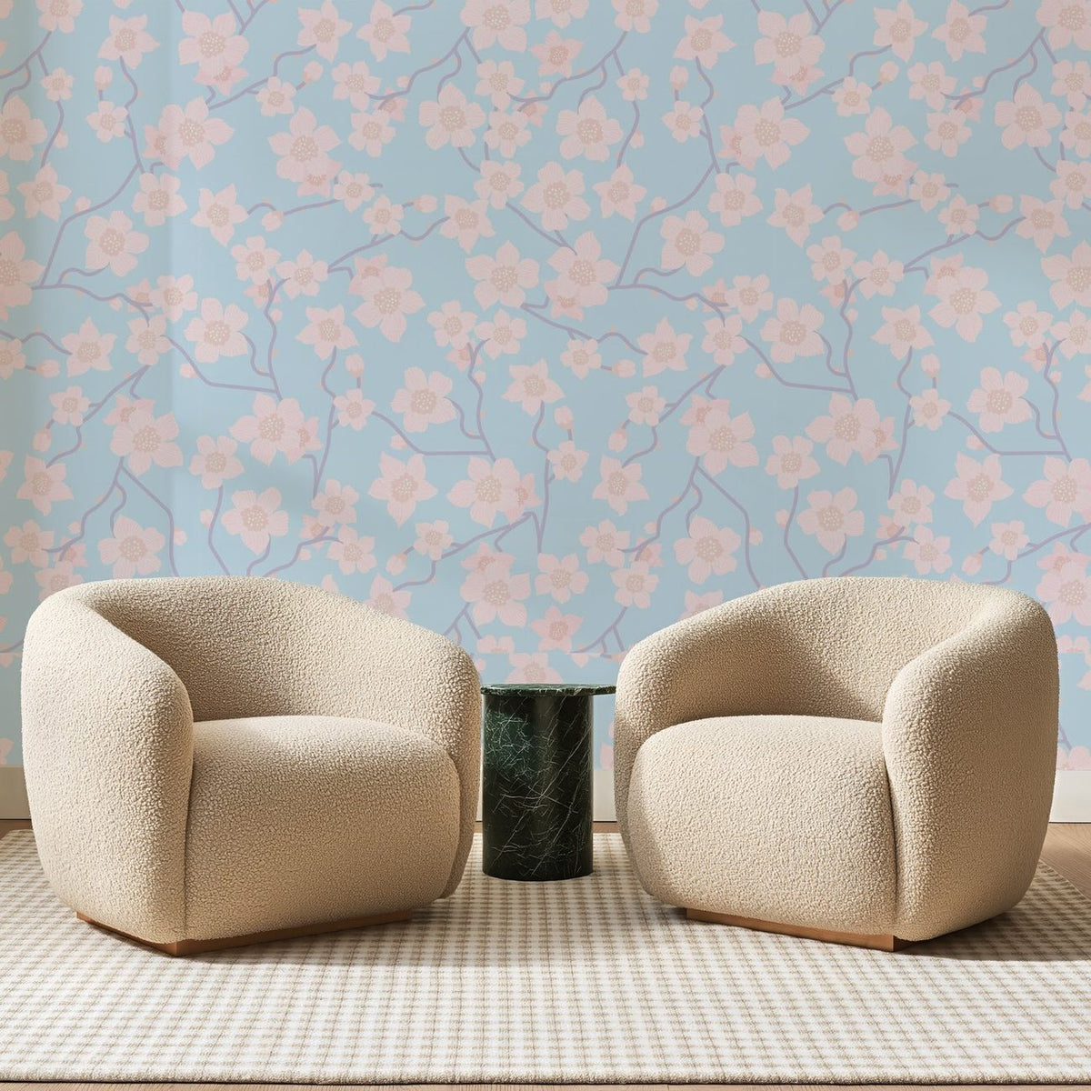 Papier peint panoramique Cerisier Rose Sur Bleu Ciel, posé sur toute la paroi d'un salon, derrière deux fauteuils en bouclette crème et un guéridon en marbre vert