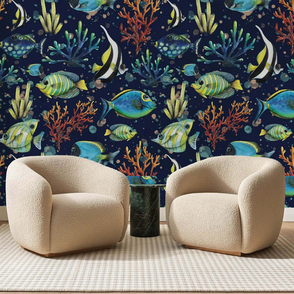 Papier peint panoramique Poissons Tropicaux Bleu Nuit, posé sur toute la paroi d'un salon, derrière deux fauteuils en bouclette crème et un guéridon en marbre vert