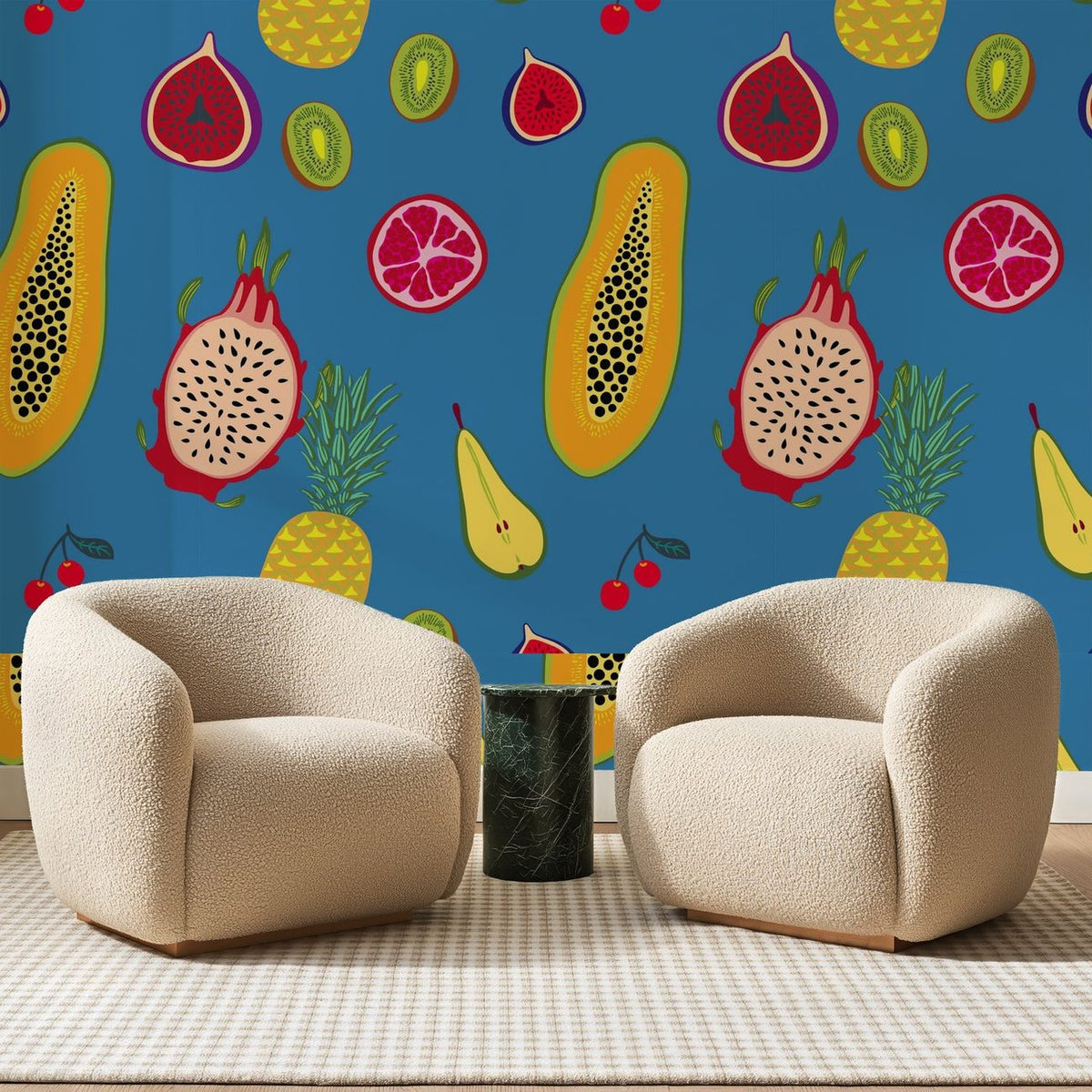 Papier peint panoramique Fruits Exotiques sur Bleu Franc, posé sur toute la paroi d'un salon, derrière deux fauteuils en bouclette crème et un guéridon en marbre vert