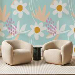 Papier peint panoramique Marguerites Sur Fond Menthe, posé sur toute la paroi d'un salon, derrière deux fauteuils en bouclette crème et un guéridon en marbre vert