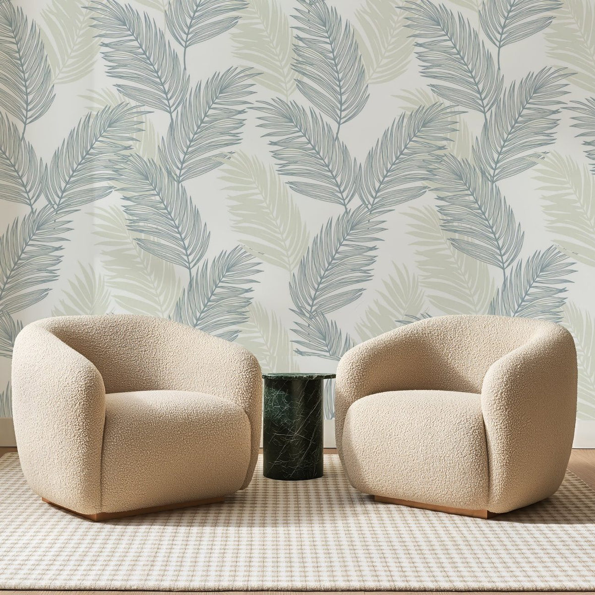 Papier peint panoramique Palmes Bleu Ardoise et Sable, posé sur toute la paroi d'un salon, derrière deux fauteuils en bouclette crème et un guéridon en marbre vert