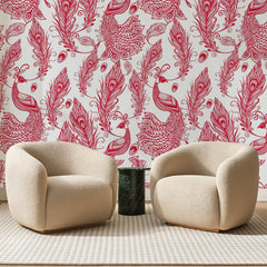 Papier peint panoramique Paons au Trait Framboise, posé sur toute la paroi d'un salon, derrière deux fauteuils en bouclette crème et un guéridon en marbre vert