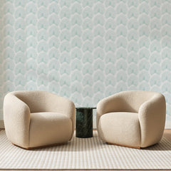 Papier peint panoramique Petites Palmes Vert d'Eau, posé sur toute la paroi d'un salon, derrière deux fauteuils en bouclette crème et un guéridon en marbre vert
