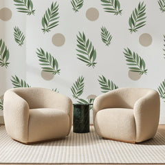 Papier peint panoramique Palmes Vertes et Cercles Sable, posé sur toute la paroi d'un salon, derrière deux fauteuils en bouclette crème et un guéridon en marbre vert
