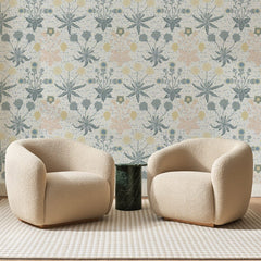 Papier peint panoramique Fleurettes Bleu Gris sur Crème, posé sur toute la paroi d'un salon, derrière deux fauteuils en bouclette crème et un guéridon en marbre vert