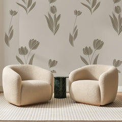 Papier peint panoramique Tulipes Taupe sur Grège, posé sur toute la paroi d'un salon, derrière deux fauteuils en bouclette crème et un guéridon en marbre vert