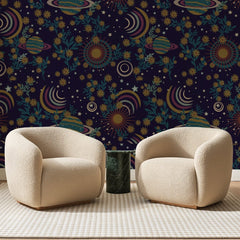 Papier peint panoramique Cosmos Nocturne Aubergine, posé sur toute la paroi d'un salon, derrière deux fauteuils en bouclette crème et un guéridon en marbre vert