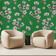Papier peint panoramique Coton Fleuri sur Vert Trèfle, posé sur toute la paroi d'un salon, derrière deux fauteuils en bouclette crème et un guéridon en marbre vert