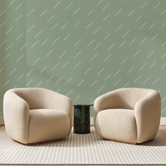 Papier peint panoramique Traits Obliques Vert Sauge, posé sur toute la paroi d'un salon, derrière deux fauteuils en bouclette crème et un guéridon en marbre vert