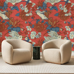 Papier peint panoramique Perroquets Blancs sur Vermillon, posé sur toute la paroi d'un salon, derrière deux fauteuils en bouclette crème et un guéridon en marbre vert