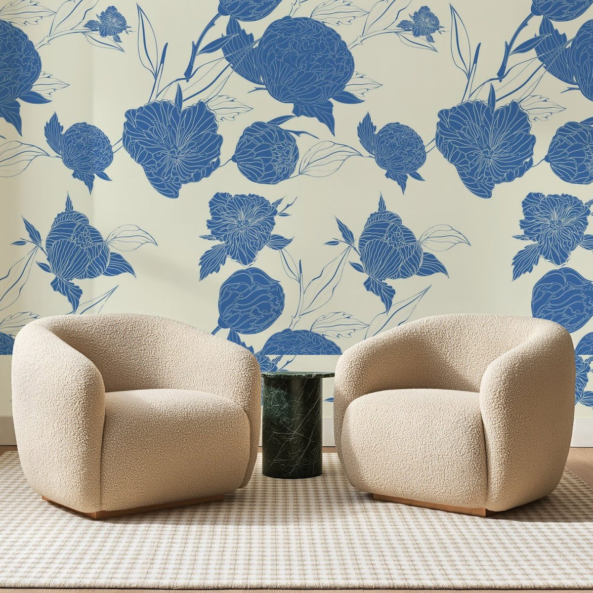 Papier peint panoramique Pivoines Bleues sur Crème, posé sur toute la paroi d'un salon, derrière deux fauteuils en bouclette crème et un guéridon en marbre vert
