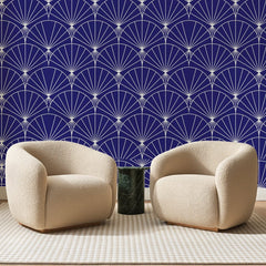 Papier peint panoramique Arcs Rayonnants Bleu Marine, posé sur toute la paroi d'un salon, derrière deux fauteuils en bouclette crème et un guéridon en marbre vert