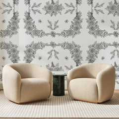 Papier peint panoramique Guirlandes de Roses Grises, posé sur toute la paroi d'un salon, derrière deux fauteuils en bouclette crème et un guéridon en marbre vert