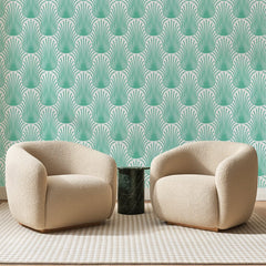 Papier peint panoramique Plumes Turquoise sur Blanc, posé sur toute la paroi d'un salon, derrière deux fauteuils en bouclette crème et un guéridon en marbre vert