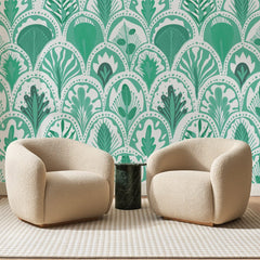 Papier peint panoramique Écailles Feuillues Vert Jade, posé sur toute la paroi d'un salon, derrière deux fauteuils en bouclette crème et un guéridon en marbre vert