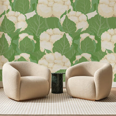 Papier peint panoramique Choux-Fleurs Vert Sauge, posé sur toute la paroi d'un salon, derrière deux fauteuils en bouclette crème et un guéridon en marbre vert