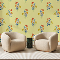 Papier peint panoramique Bouquets Champêtres Jaune Pâle, posé sur toute la paroi d'un salon, derrière deux fauteuils en bouclette crème et un guéridon en marbre vert