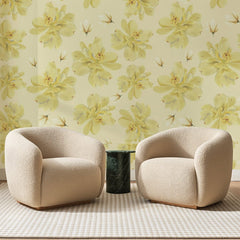 Papier peint panoramique Grandes Corolles Jaune Pâle, posé sur toute la paroi d'un salon, derrière deux fauteuils en bouclette crème et un guéridon en marbre vert