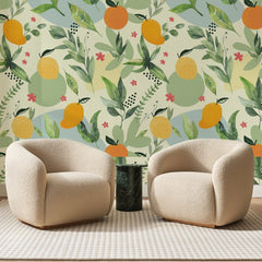 Papier peint panoramique Verger Fleuri Crème, posé sur toute la paroi d'un salon, derrière deux fauteuils en bouclette crème et un guéridon en marbre vert