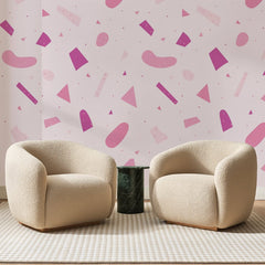 Papier peint panoramique Terrazzo Rose Fuchsia, posé sur toute la paroi d'un salon, derrière deux fauteuils en bouclette crème et un guéridon en marbre vert