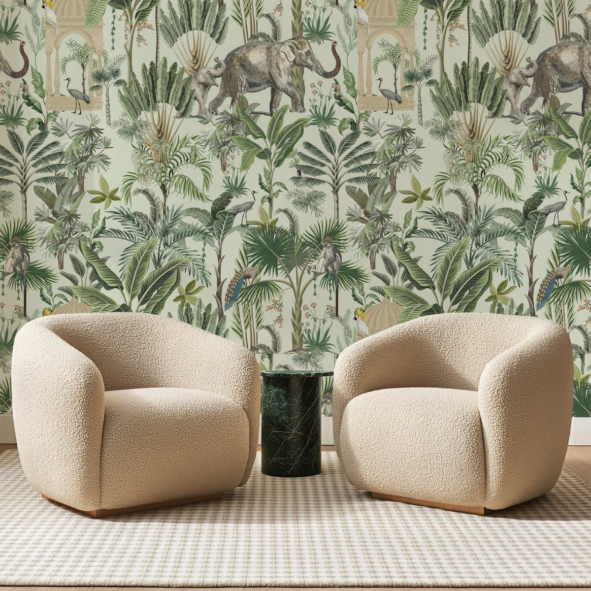 Papier peint panoramique Jardin aux Éléphants Vert Pâle, posé sur toute la paroi d'un salon, derrière deux fauteuils en bouclette crème et un guéridon en marbre vert