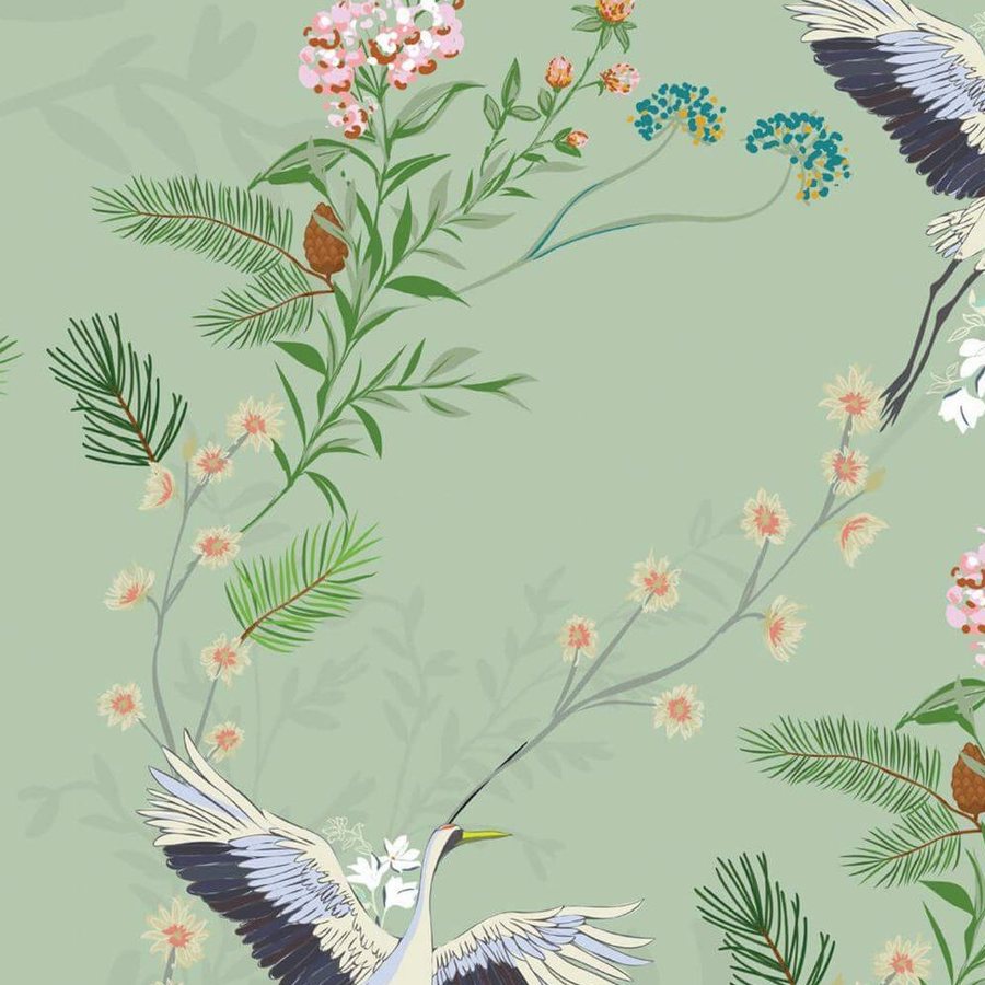 Gros plan sur l'aile noire et blanche d'une grue et une fleurette rose imprimées sur vert sauge.