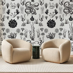 Papier peint panoramique Fonds Marins Noir Et Blanc, posé sur toute la paroi d'un salon, derrière deux fauteuils en bouclette crème et un guéridon en marbre vert