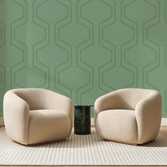 Papier peint panoramique Tracé Hexagonal Vert Sauge, posé sur toute la paroi d'un salon, derrière deux fauteuils en bouclette crème et un guéridon en marbre vert