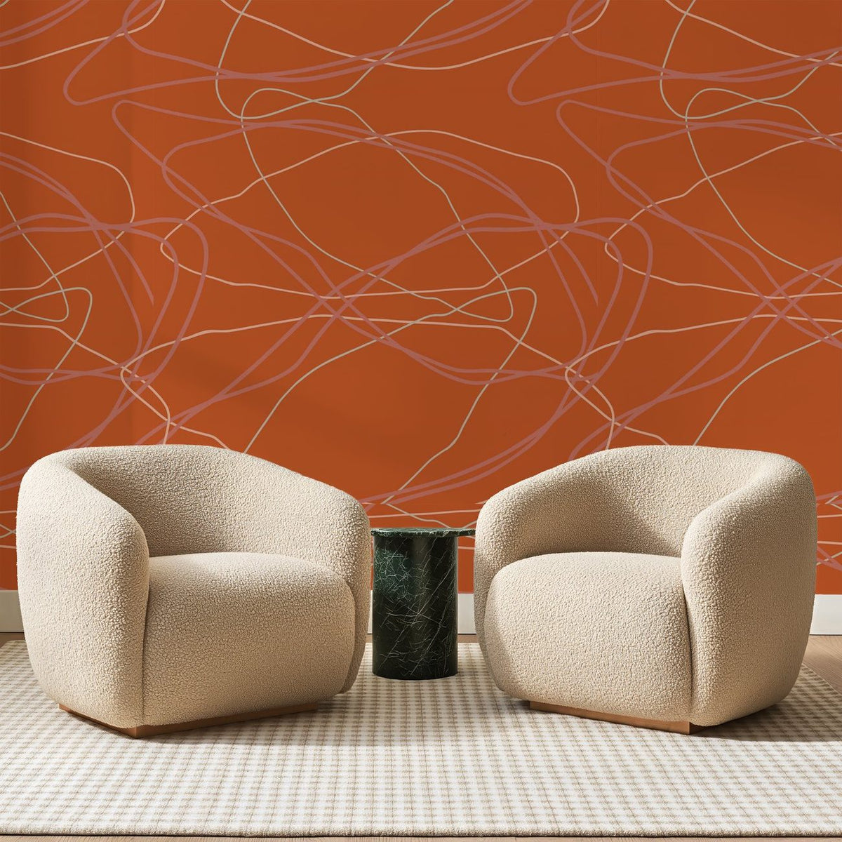 Papier peint panoramique Lacis de Lignes Terracotta, posé sur toute la paroi d'un salon, derrière deux fauteuils en bouclette crème et un guéridon en marbre vert