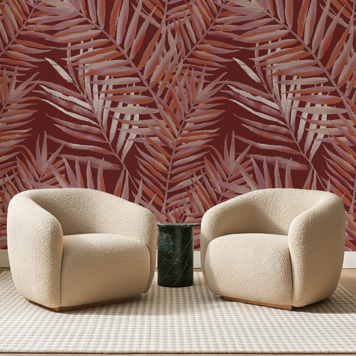 Papier peint panoramique Palmes Rosées sur Fond Brique, posé sur toute la paroi d'un salon, derrière deux fauteuils en bouclette crème et un guéridon en marbre vert