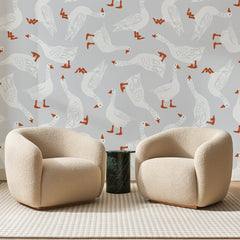 Papier peint panoramique Troupeau d'Oies Gris Perle, posé sur toute la paroi d'un salon, derrière deux fauteuils en bouclette crème et un guéridon en marbre vert