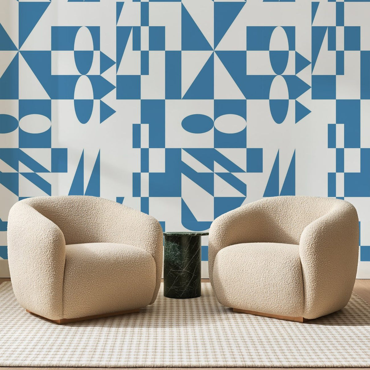 Papier peint panoramique Assemblage Géométrique Bleu, posé sur toute la paroi d'un salon, derrière deux fauteuils en bouclette crème et un guéridon en marbre vert