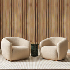 Papier peint panoramique Tasseaux de Bois Miel, posé sur toute la paroi d'un salon, derrière deux fauteuils en bouclette crème et un guéridon en marbre vert