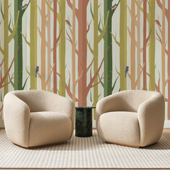 Papier peint panoramique Forêt d'Arbres Nus Terracotta, posé sur toute la paroi d'un salon, derrière deux fauteuils en bouclette crème et un guéridon en marbre vert