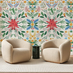 Papier peint panoramique Jardin Folklorique Crème, posé sur toute la paroi d'un salon, derrière deux fauteuils en bouclette crème et un guéridon en marbre vert
