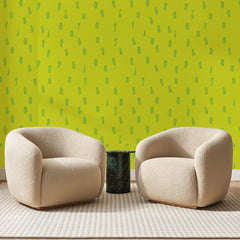 Papier peint panoramique Touches Vertes sur Chartreuse, posé sur toute la paroi d'un salon, derrière deux fauteuils en bouclette crème et un guéridon en marbre vert