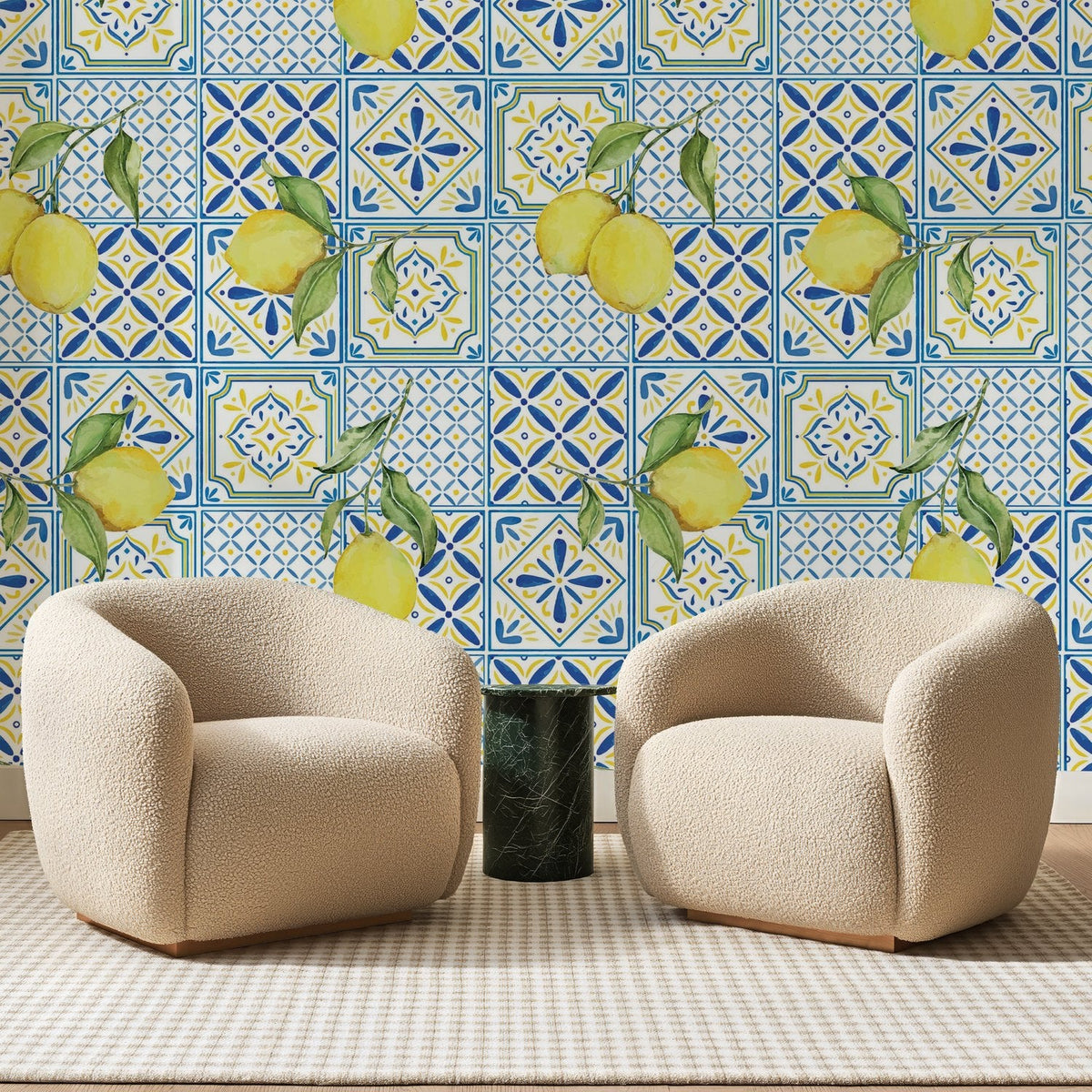 Papier peint panoramique Citrons et Carreaux Bleu Roi, posé sur toute la paroi d'un salon, derrière deux fauteuils en bouclette crème et un guéridon en marbre vert