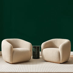 Papier peint panoramique Uni Vert Bouteille, posé sur toute la paroi d'un salon, derrière deux fauteuils en bouclette crème et un guéridon en marbre vert