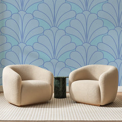 Papier peint panoramique Grandes Palmettes Bleu Ciel, posé sur toute la paroi d'un salon, derrière deux fauteuils en bouclette crème et un guéridon en marbre vert