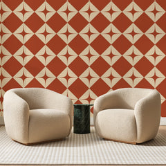 Papier peint panoramique Losanges Étoilés Terracotta, posé sur toute la paroi d'un salon, derrière deux fauteuils en bouclette crème et un guéridon en marbre vert